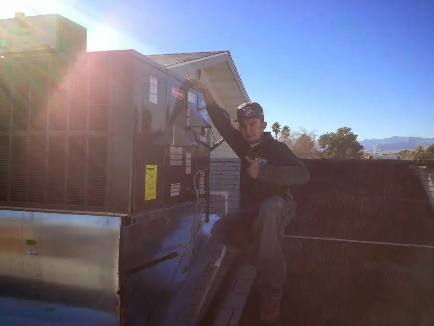 HVAC technician performing Air Duct Repair on a rooftop unit in Peachtree City